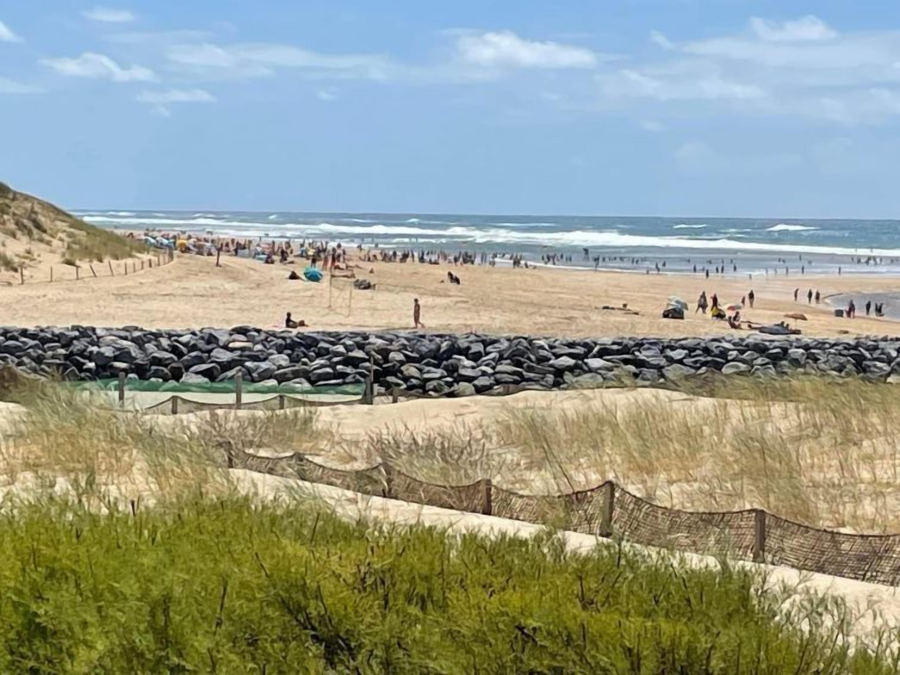 Een strand met een rotsbarrière en een heldere lucht.