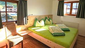A room with a bed, a chair, and a window with curtains. - Apartment Plank by Interhome (Kaltenbach)