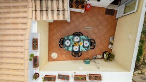 A rooftop patio with a dining table, chairs, potted plants, a water dispenser, and a small window. - Rua 5 de Outubro by Interhome (Lagos)