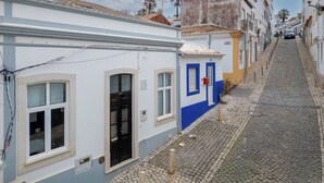 A narrow cobblestone street lined with buildings featuring traditional architecture, a visible door, and a small plant on the ground. - Rua 5 de Outubro by Interhome (Lagos)