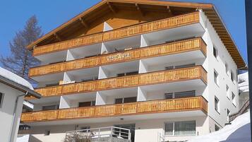 A multi-story building with wooden balconies and the name "VISCARIA" on the facade.