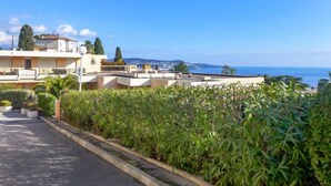 Zona residencial con vistas despejadas al mar, con edificios modernos y abundante vegetación.