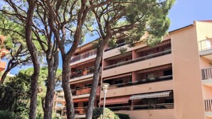 A multi-story building with balconies, surrounded by trees. - Les Pins Ensoleilles by Interhome (Sainte Maxime)