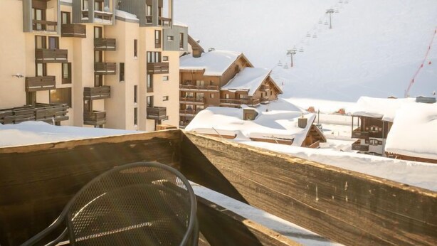A snow-covered mountain town with modern and traditional buildings, ski lifts, and a chairlift visible. - Les Tufs (Val Claret) by Interhome (Tignes)
