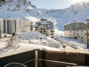 A snow-covered mountain town with modern buildings, including a hotel with multiple floors and balconies. - Les Tufs (Val Claret) by Interhome (Tignes)