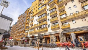 Un hôtel à plusieurs étages doté de balcons, d’une terrasse et d’un restaurant.