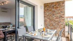 Un comedor con una mesa dispuesta para dos personas, una pared de piedra y vistas al exterior.