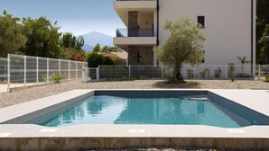 Un edificio moderno de dos pisos con una piscina delantera.