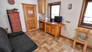Une petite pièce agréable, avec un lit, un bureau en bois, une télévision et une fenêtre.