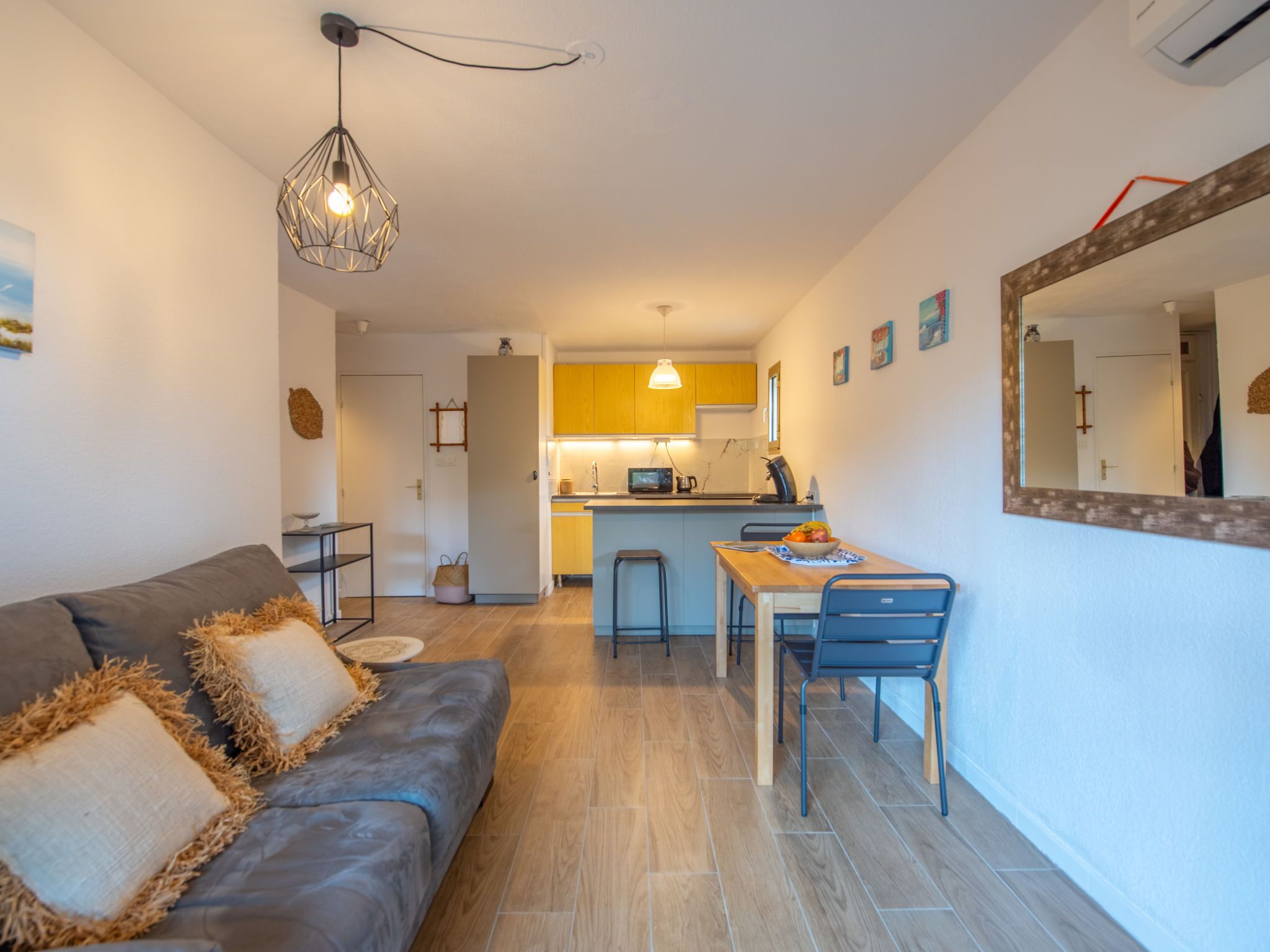A modern apartment with a living room, kitchenette, and dining area.