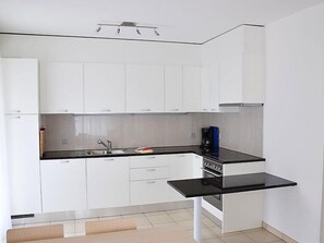 Enjoy cooking in this well-equipped kitchen with an oven, coffee machine, and sink.