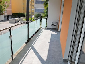 Enjoy the view from this balcony with a glass railing and tiled floor, perfect for taking in the sights.