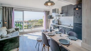 Eine moderne Küche mit Essbereich, großen Fenstern und Blick auf das Meer.