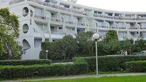 Un edificio moderno con un diseño arquitectónico único que presenta balcones curvos y ventanas circulares.