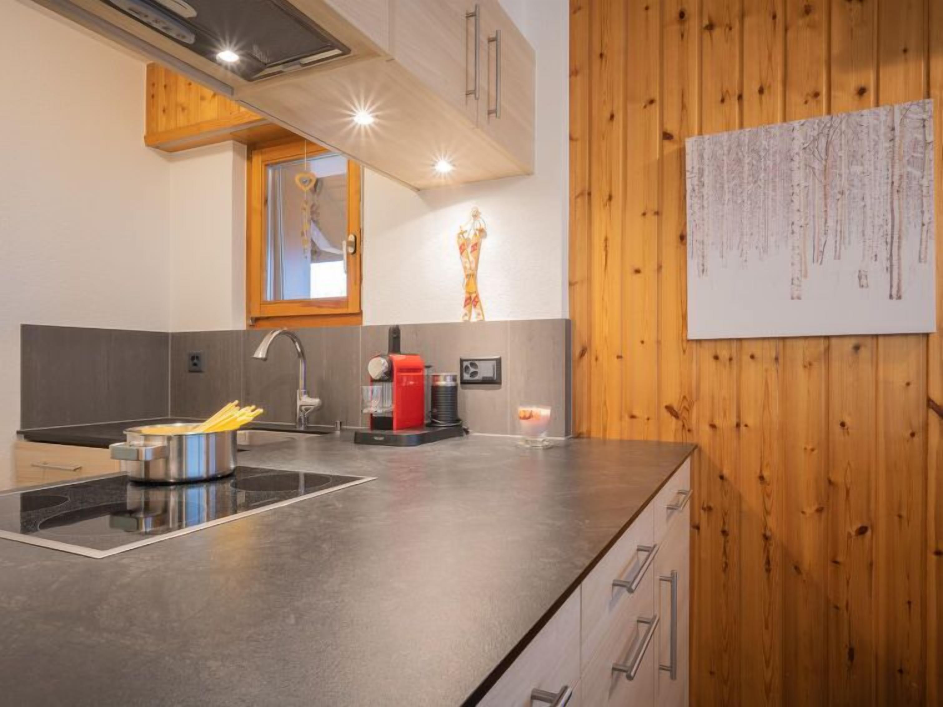 Eine moderne Küche mit schwarzem Arbeitsplatz, Edelstahlgeräten und Holzschränken.
