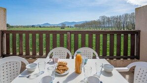 A table set outdoors with a view of a vineyard and mountains in the background. - Les Embruns by Interhome (Saint Cyprien)