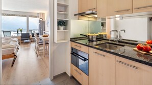 Een moderne keuken met houten kastjes, een granieten aanrechtblad en een ingebouwde oven.