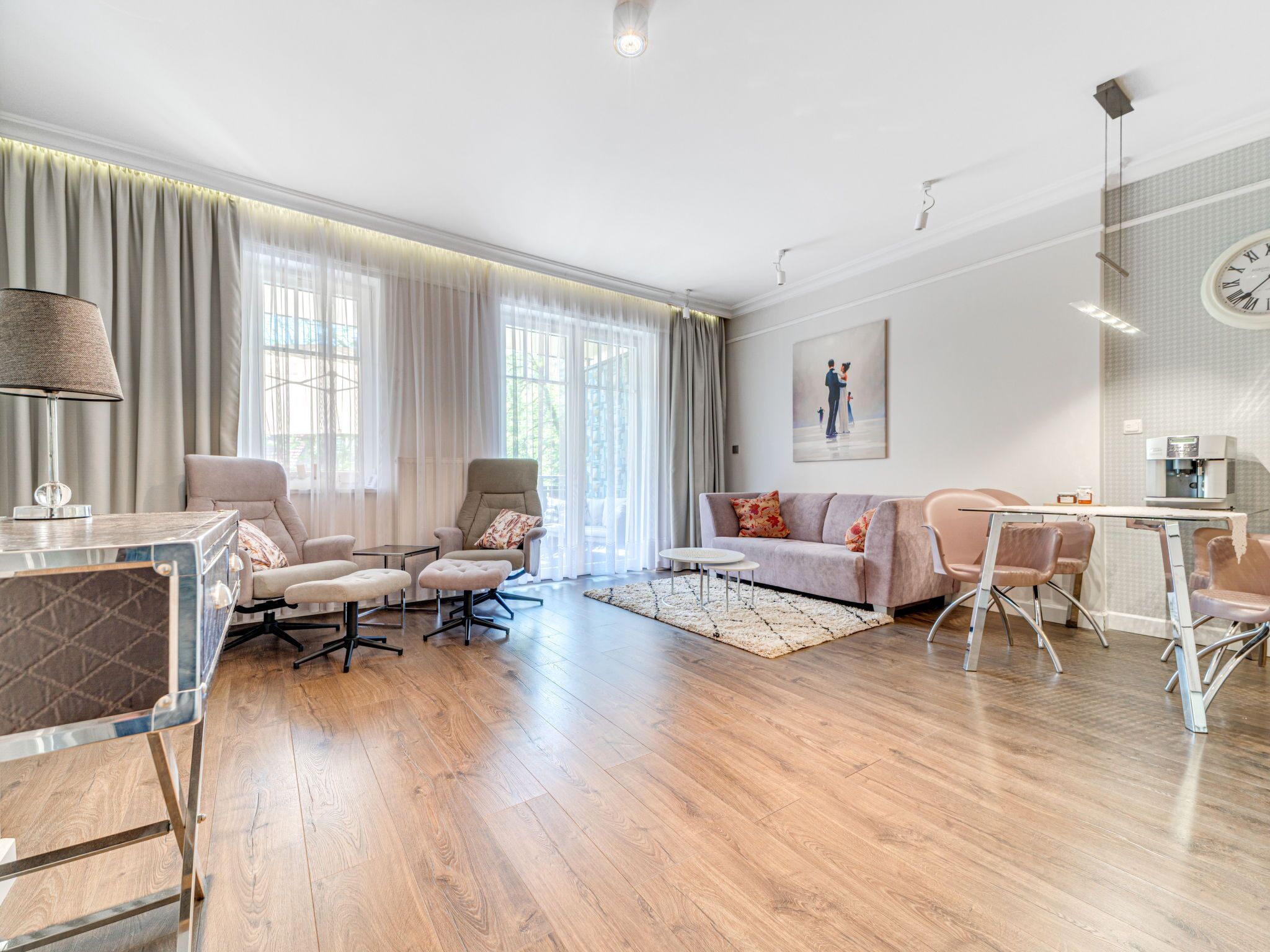 A modern living room with a sofa, chairs, a coffee table, and a dining area with a table and chairs.
