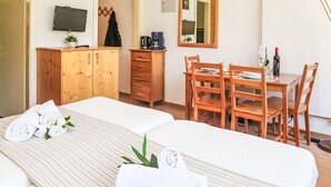 A hotel room with two beds, a wooden desk with chairs, a television, and a mirror. - Rosablanche C22 by Interhome (Siviez-Nendaz)