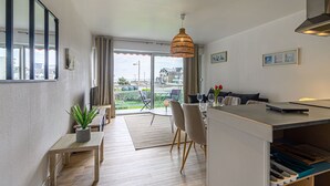 Eine moderne Küche mit Essbereich, großen Fenstern und Blick ins Freie.