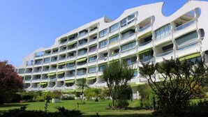 Un hôtel moderne doté de nombreux balcons et d’un jardin à l’avant.