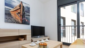 A modern room with a wooden table, a flat-screen TV, and a balcony with a railing. - Escorxador by Interhome (Colera)