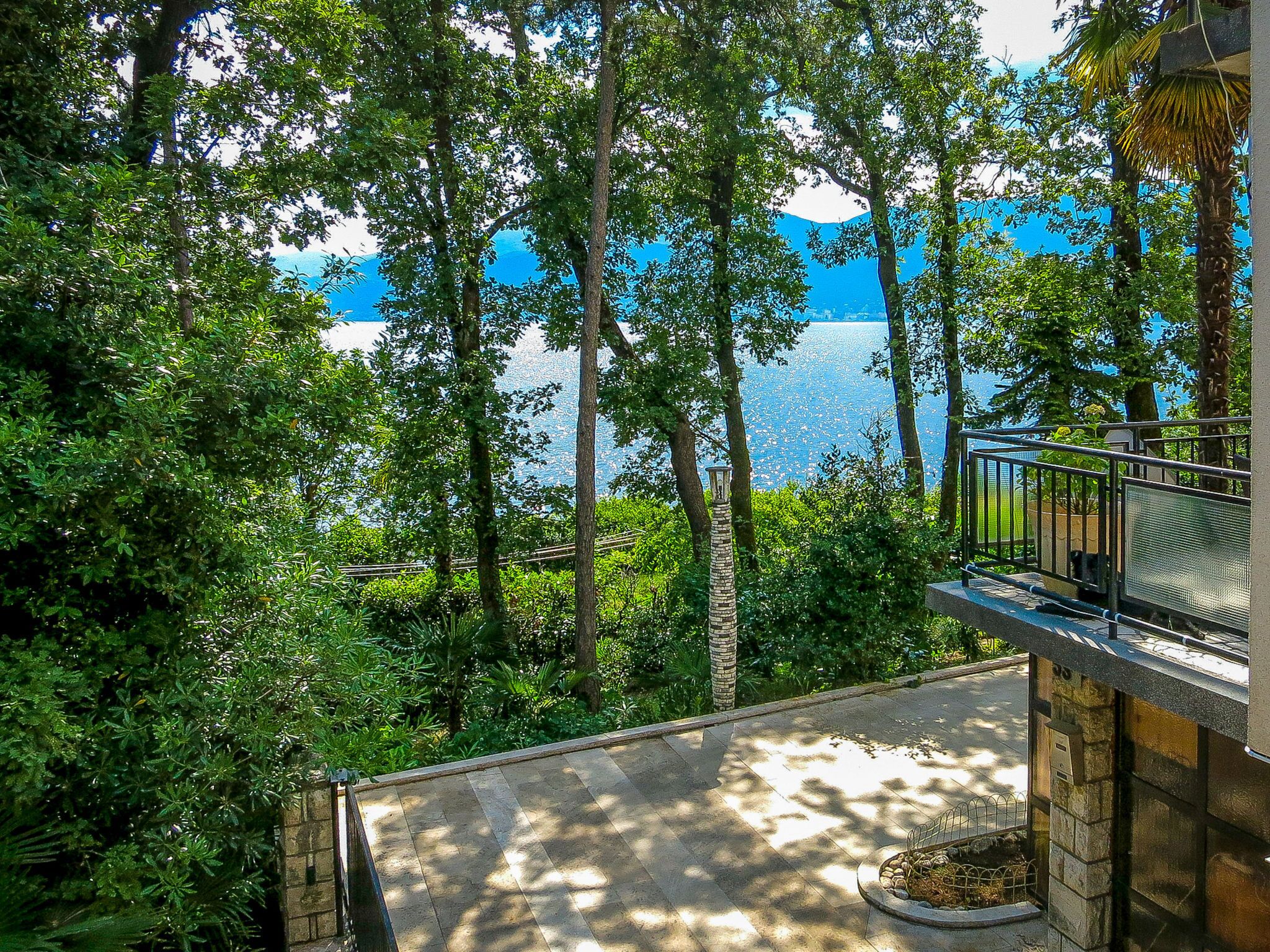 Un balcon donnant sur un lac entouré d’arbres.