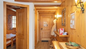A wooden interior with a bed, a table with a bowl, and a chair. - Pinot Gris combles by Interhome (Verbier)