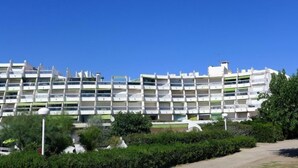A multi-story hotel with a modern design, featuring balconies and a central courtyard. - Apartment Arena by Interhome (La Grande Motte)