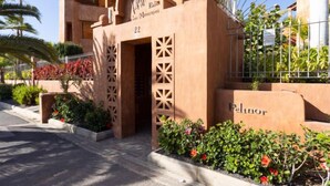 A building with a modern architectural style, featuring a prominent entrance with a decorative arch and a sign above it. - Duplex Bencomo by Interhome (Palm- Mar)