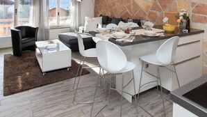A modern kitchen with a stone backsplash, a dining area with white chairs, and a cozy seating area with a sofa and a coffee table. - Apartment Stem 2 by Interhome (Verbier)