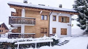 A two-story wooden building with a balcony, surrounded by snow. - Apartment Stem 2 by Interhome (Verbier)