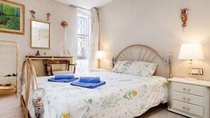 Une chambre à coucher avec un lit, des tables de chevet, un bureau et une chaise.