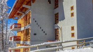 Un immeuble  à plusieurs étages dont la façade porte une enseigne indiquant « TALISMAN ».