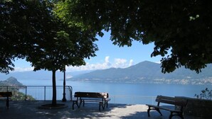 Een park met banken en uitzicht op een meer en bergen.