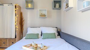 A neatly arranged hotel room with a bed, bedside tables, and a tray with breakfast items. - Rose des Vents by Interhome (Quiberon)