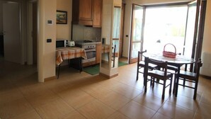 Una cocina con una mesa de comedor y sillas, estufa y armarios.