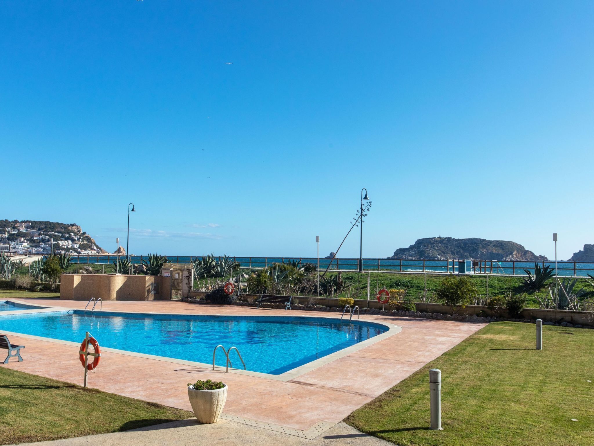 Une piscine avec vue sur la mer et les collines en arrière-plan.