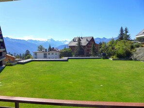 Surrounded by a serene mountainous landscape, this property offers a picturesque view from its well-maintained lawn area.