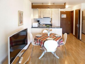 Cozy apartment with a dining area, kitchenette, and flat-screen TV.