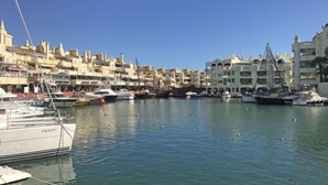 Una marina con imbarcazioni ormeggiate, circondata da edifici a più piani con balconi.