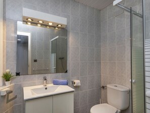 A bathroom with a sink, mirror, toilet, and shower. - Rosa Maria by Interhome (Llançà)