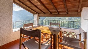 A wooden balcony with a table and chairs, overlooking a mountainous landscape. - Canneto by Interhome (Marina di Andora)