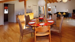 A dining area with a wooden table set for four, surrounded by chairs. - Chalet Almisgässli by Interhome (Grindelwald)