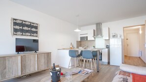 Een moderne keuken met een eetgedeelte, een flatscreen televisie en een gezellige zithoek.