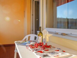 A table with a wine bottle, a glass, and red berries.
