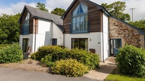 A modern two-story house with a combination of brick and white exterior walls, large windows, and a sloped roof. - Villa Gallery by Interhome (Truro)