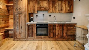 Une cuisine avec des meubles en bois, un four encastré et un évier.