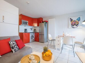 A modern apartment with a kitchen, dining area, and living room.
