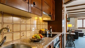 A kitchen with wooden cabinets, a granite countertop, a stainless steel sink, and a fruit bowl. - Residenza Chesa Margun 78-3 by Interhome (Silvaplana-Surlej)
